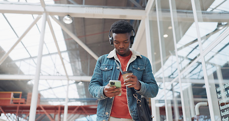 Image showing City, phone and black man walking with coffee in urban building on social media, internet and social network. Technology, travel and male with smartphone, drinking coffee and headphones for music