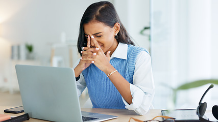 Image showing An overworked business woman with a headache while working in her office. A tired or stressed corporate female in pain at the workplace. A young entrepreneur suffering from fatigue