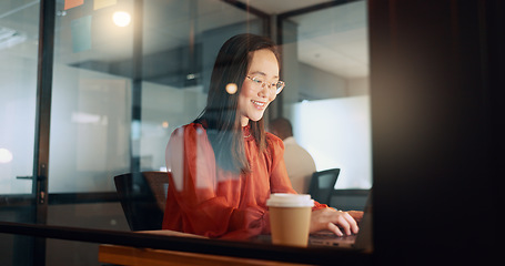 Image showing Laptop, night office and Asian woman typing email, sales proposal or finishing project deadline. Computer, tech and happy female employee working late in dark workplace, researching or writing report