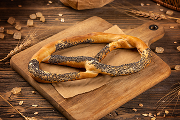 Image showing Freshly baked pretzel with poppy seeds