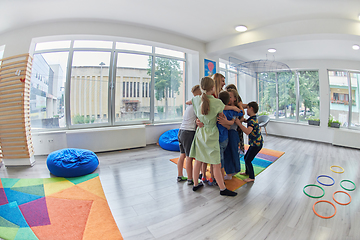 Image showing A child hugging a teacher in a modern kindergarten