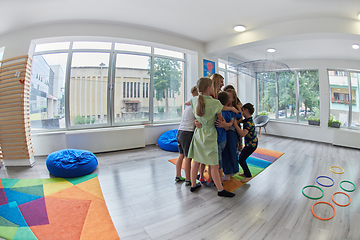 Image showing A child hugging a teacher in a modern kindergarten