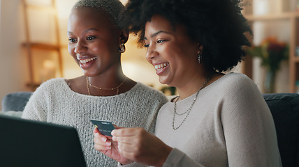 Image showing Payment, credit card and friends online shopping on a laptop for discount or sale on a digital fintech website at home. Ecommerce, happy and excited African women on the sofa banking on the internet