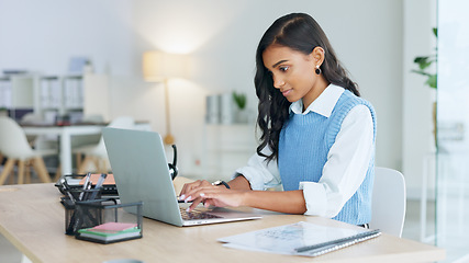 Image showing Young woman happily doing business and networking by email on laptop. Professional female is stylish and creative while being alone in office. She is using technology to advance her career