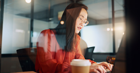 Image showing Laptop, night office and Asian woman typing email, sales proposal or finishing project deadline. Computer, tech and happy female employee working late in dark workplace, researching or writing report