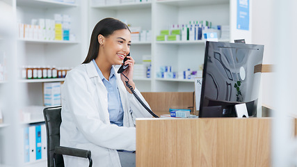 Image showing Pharmacist woman answering the telephone and giving advice to customer on flu shot treatment options in pharmacy. Chemist assisting remote client by checking medicine stock on their computer database