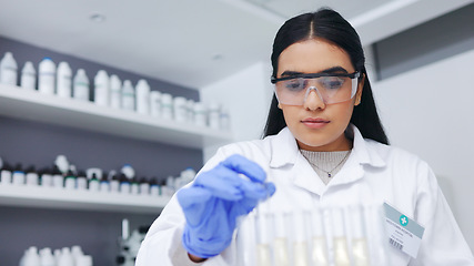 Image showing Young female scientists doing tube testing in a modern laboratory. Micro biologist examine liquid bacteria in glassware mixture to invent a vaccine cure for virus at innovative research hospital