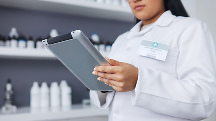 Image showing Young scientist using a digital tablet and microscope in a lab. Female pathologist analyzing medical samples while doing experiments to develop a cure. Microbiologist conducting forensic research