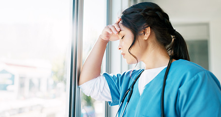 Image showing Woman doctor, headache and burnout by window with stress, tired or sad in hospital workplace with pain in head. Professional medic, mental health problem and clinic with anxiety from healthcare job