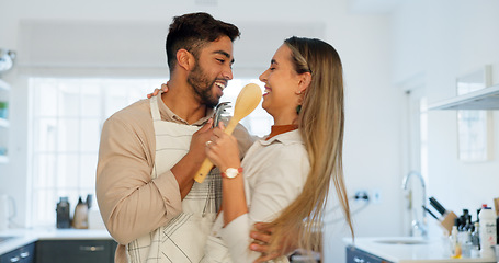 Image showing Singing, happy and dancing funny couple together in a kitchen at home enjoy their relationship and crazy together. Man and woman sharing playful dance, love and smile after cooking with apron in home