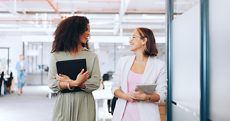 Image showing Creative business woman, tablet and walking in discussion, laughing or joke together at office. Happy women employee designers having a walk for social or funny conversation in startup at workplace