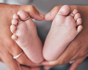 Image showing Baby, feet and hands of mother closeup with newborn for love, care or family bond in their home. Zoom, mom and foot of infant for motherhood, protection or child development, maternity and caring