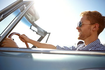 Image showing Happy, young man and driving for summer vacation, road trip or journey for freedom in the outdoors. Male taking a drive in car with smile enjoying outdoor travel on a warm sunny day with sunglasses