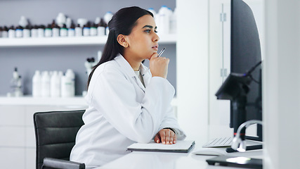 Image showing Young scientist using a computer and microscope in a lab. Female pathologist analyzing medical samples while doing experiments to develop a cure. Microbiologist conducting forensic research