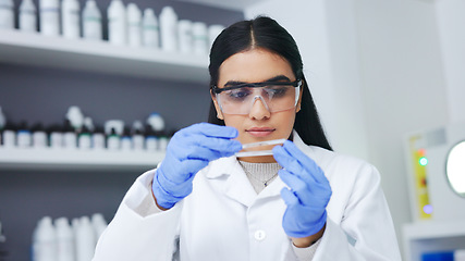 Image showing Young female scientist doing research to find a cure for an illness or disease while working in a laboratory alone. Serious and expert medical biologist doing an experiment for progress in healthcare