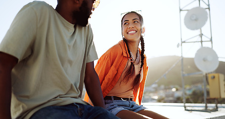 Image showing Summer, couple and rooftop date with happy, smile and relax woman and man talking, bonding and laughing. Love, sunset and interracial guy and lady enjoying the view of the city while flirting outdoor