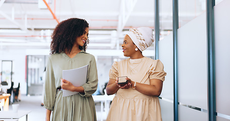 Image showing Business team, talking and walking together for communication, gossip or happy conversation while working at a coworking office. Black women with a phone and paperwork while sharing ideas and advice