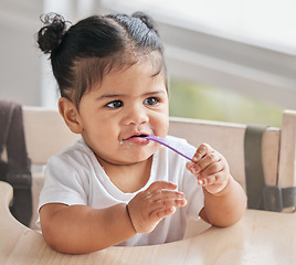 Image showing Baby, eating and girl with toddler food for nutrition and child growth in a kitchen at home. Youth, hungry and spoon of a kid in the morning on a children high chair in a house getting fed a meal