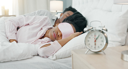 Image showing Black woman waking up in bed to switch off her alarm clock with a sleep mask in her house. Lazy, sleepy and African girl sleeping in her comfortable bedroom with an early morning get up time at home.