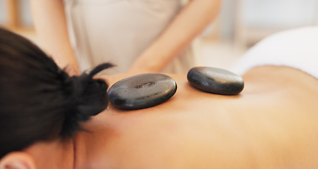 Image showing Hands, masseuse or hot stone massage in spa, salon or healthcare wellness retreat in self care, muscle release or stress management. Women, back or luxury rocks in zen, calm or relax skincare therapy