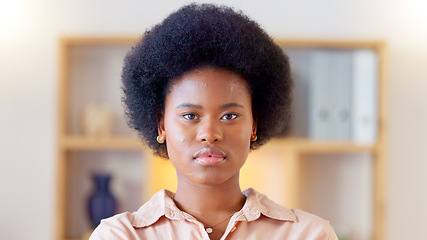 Image showing Portrait of a serious african woman at home standing inside her living room. Face of a young trendy female with an afro looking confident and relaxed. Beautiful student with natural makeup staring