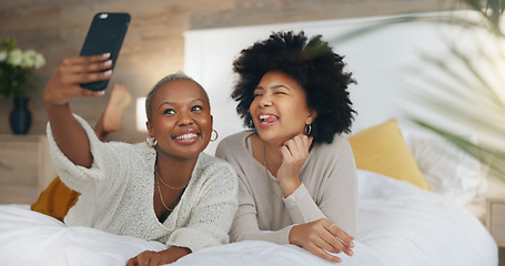 Image showing Happy, friends and selfie with phone in bed with a smile, relax and funny during a luxury vacation in a hotel room. African american women having fun with social media post on a 5g mobile smartphone