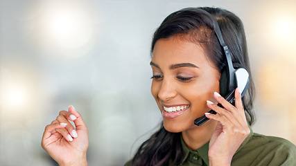 Image showing Happy female customer service agent smiling while working in a call centre and talking to a client with a headset. A helpful saleswoman assisting customers with purchase orders and questions online