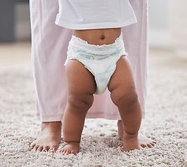 Image showing Baby legs, learning and walking with mother, support and first steps of healthy body development. Closeup mom teaching child to walk, balance and feet on carpet for growth, milestone and motor skills