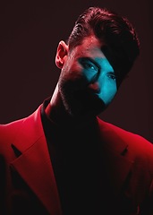 Image showing Art, neon light and reflection, portrait of man with eyes in lighting on serious face and self expression. Futuristic fashion, male model and beauty with red and blue studio lights on dark background