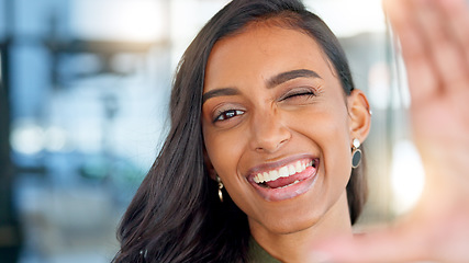 Image showing Face of a happy business woman smiling, making funny expressions and creating a frame with her hand while standing in an office at work. Portrait of a smiling, carefree and cheerful female having fun