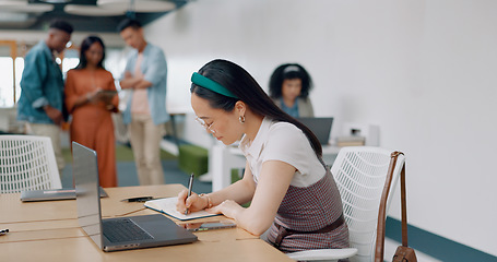 Image showing Asian woman, laptop and writing in notebook for planning strategy, schedule management or finance checklist in office. Employee, reading email communication and notes for creative startup company