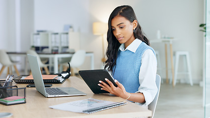 Image showing Trendy marketing professional using an online app to network, meet deadlines and stay connected during office hours. Young business woman using her laptop and tablet while working in the office.