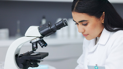 Image showing Female scientist using a microscope in a research lab. Young biologist or biotechnology researcher working and analyzing microscopic samples with the latest laboratory tech equipment