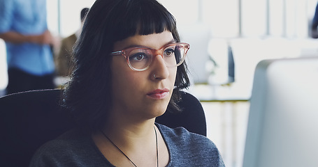 Image showing Computer, serious and business woman working in an office at a startup company planning in an agency using internet. Employee, worker or female journalist brainstorming a story at her workplace