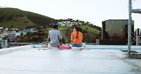 Image showing Couple, city rooftop and relax together with love, friendship and romance during a sunset picnic. Urban friends, freedom and peace talking on lunch date in Cape Town South Africa cityscape background