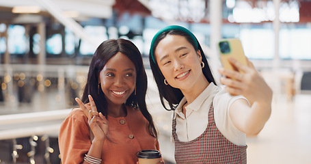 Image showing Phone selfie, women and friends with peace sign at mall taking pictures for social media. Bokeh, hand gesture and girls taking photo on mobile smartphone for profile picture or happy memory together.