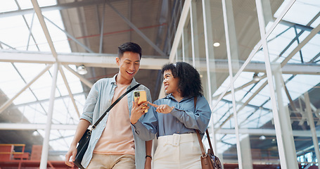 Image showing Phone, black woman and man walking in a office building talking, reading or sharing online social media news. Social networking, mobile app or employees in communication or speaking of internet