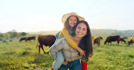 Image showing Family, farm and fun with a girl and mother playing on a grass meadow or field with cattle in the background. Agriculture, sustainability and love with a woman and her daughter enjoying time together