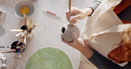 Image showing Hands, pottery mud or sculpture artist with clay cup, mug or vase in art studio, product manufacturing workshop or small business. Top view, woman and sculpting tool in creative shop or ceramic class