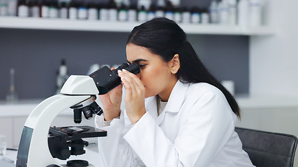 Image showing Female scientist using a microscope in a research lab. Young biologist or biotechnology researcher working and analyzing microscopic samples with the latest laboratory tech equipment