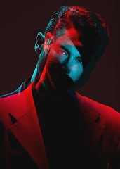 Image showing Art, neon light blur and portrait of man with reflection of lights in eyes in with serious expression on face. Futuristic fashion, male model and beauty with red and blue on dark studio background.