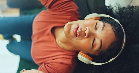 Image showing Headphones, listening and dance of black woman on a sofa excited for subscription service, technology and home connection. Happy, relax and girl portrait dancing on couch while listening to music app