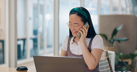 Image showing Phone call, communication and business woman writing notes in office. Laptop, cellphone and Asian woman at desk on mobile smartphone chatting, speaking or business deal conversation with contact.