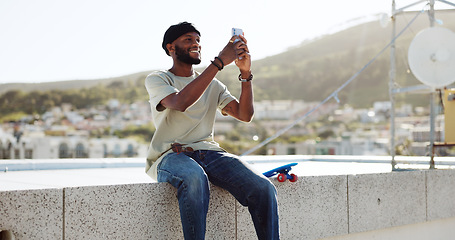 Image showing Smartphone, selfie and black man on rooftop for cityscape photography with skateboard relax outdoor. Happy man using phone or cellphone for social networking skate update of location