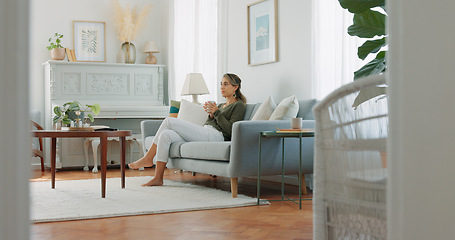 Image showing Carefree woman drinking coffee and feeling relaxed and refreshed while relaxing on the couch at home. Female taking deep breath and smelling the aroma of a hot beverage, feeling mindful and content