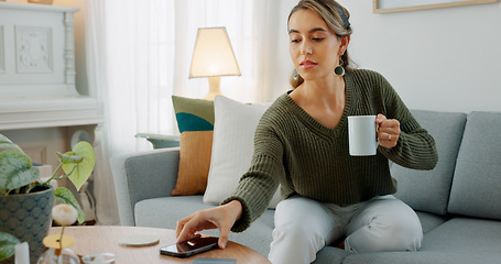 Image showing Carefree woman drinking coffee and feeling relaxed and refreshed while relaxing on the couch at home. Female taking deep breath and smelling the aroma of a hot beverage, feeling mindful and content