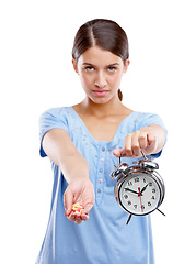 Image showing Medicine, clock and portrait of a patient in a studio waiting to take pills, vitamins or supplements. Tablets, health and young woman with alarm as a medication reminder isolated by white background.