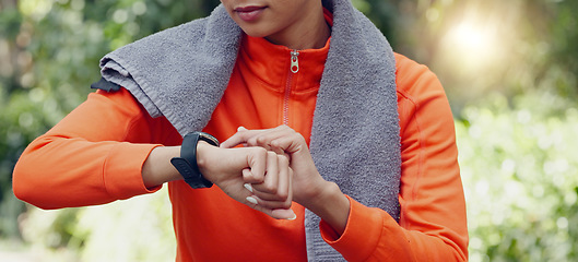 Image showing Woman fitness athlete check pulse with smartwatch while training for exercise in forest. Runner using gps tracker to monitor progress, heart rate and calories burned during workout or exercise