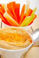 Image showing fresh hummus dip with raw carrot and celery