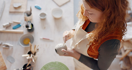 Image showing Hands, pottery mud or sculpture artist with clay cup, mug or vase in art studio, product manufacturing workshop or small business. Top view, woman and sculpting tool in creative shop or ceramic class